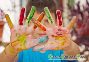 niño con manos manchadas de pintura colores